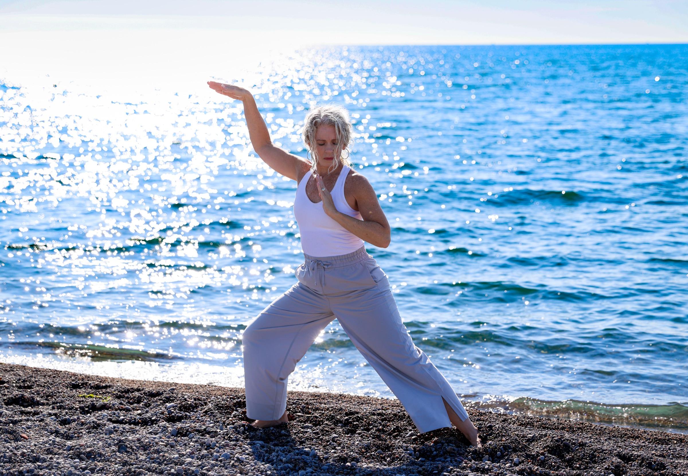 Stephanie in a grounded stance, one palm pressing forward over the water