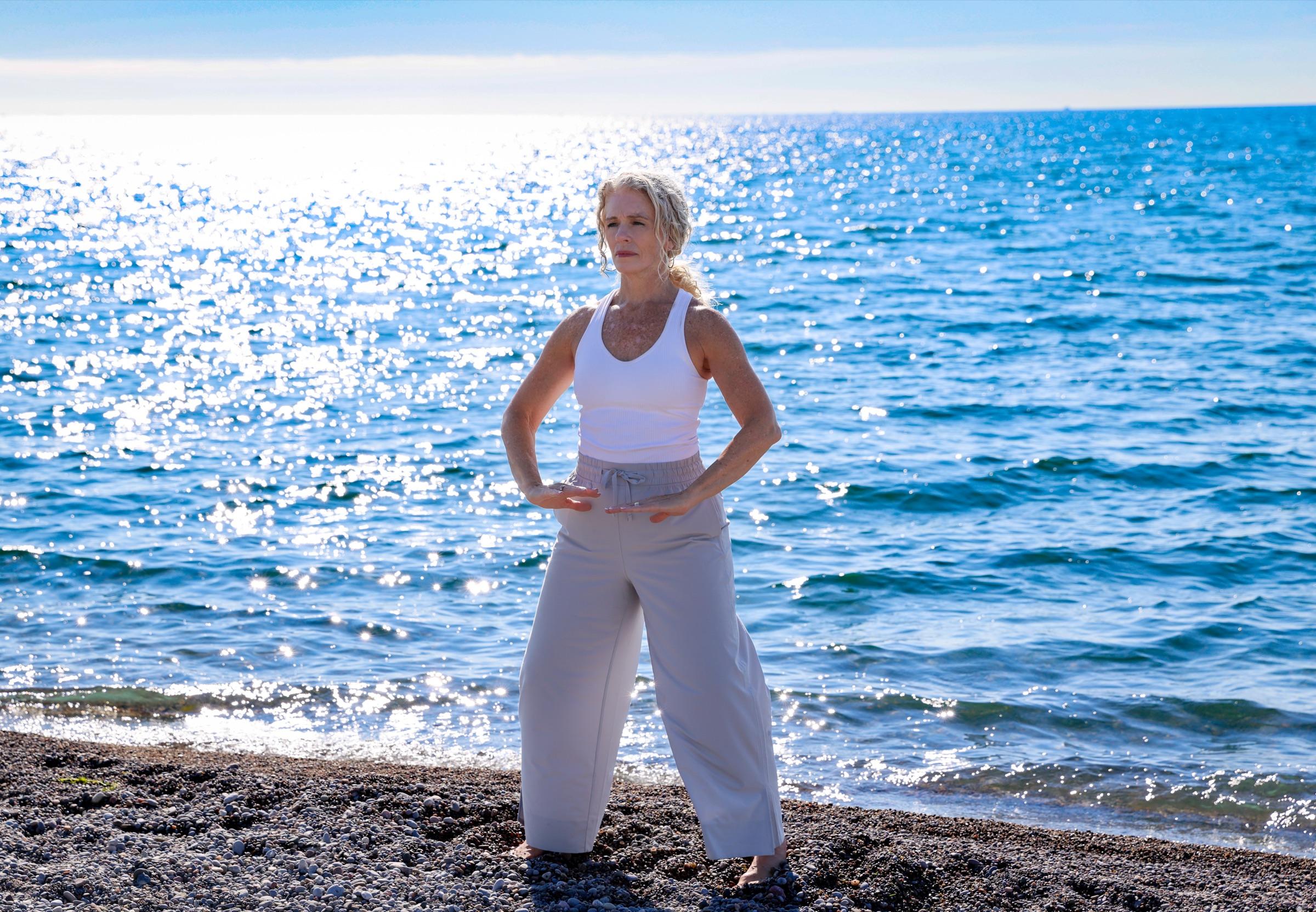 Stephanie standing relaxed with hands settled at her hips, facing the morning light